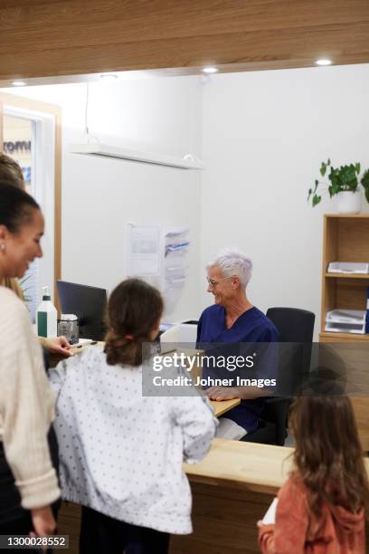family visiting doctor in health center - secretary stock pictures, royalty-free photos & images
