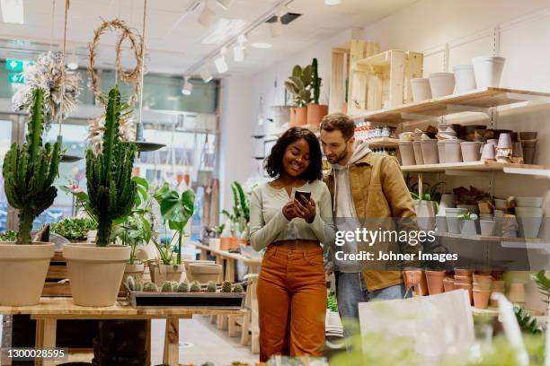 young couple in flower shop - friends shopping stock pictures, royalty-free photos & images