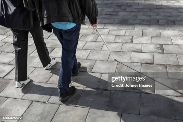 couple with white cane walking in street - 白杖 ストックフォトと画像