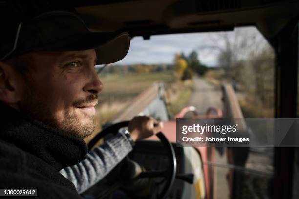 farmer driving tractor - traktor stock-fotos und bilder