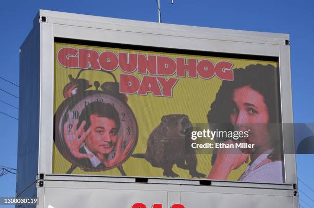 Movie screen at Snappy Burger drive-thru hamburger stand and drive-in movie theater displays images of cast members Bill Murray and Andie MacDowell...