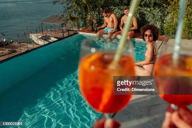freunde, die eine gute zeit am pool haben - women tanning beach drink stock-fotos und bilder
