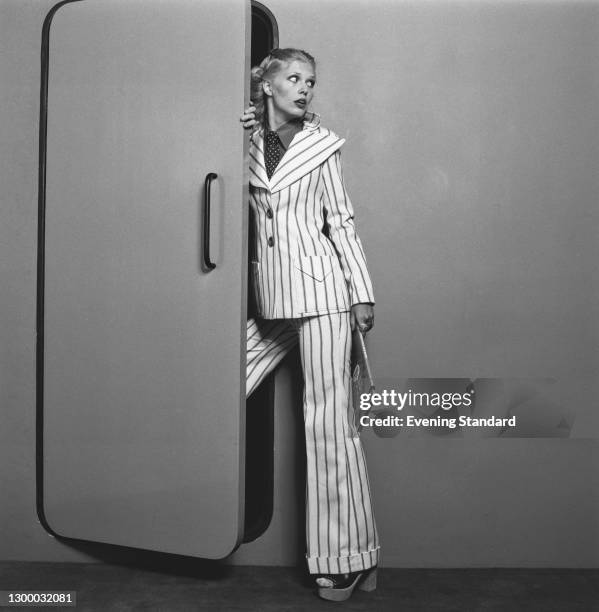 Model wearing a striped trouser suit and platform shoes, UK, 31st January 1972.