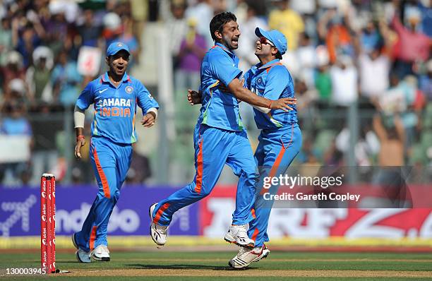 Praveen Kumar of India celebrates with Suresh Raina after dismissing Craig Kieswetter of England during the 4th One Day International between India...