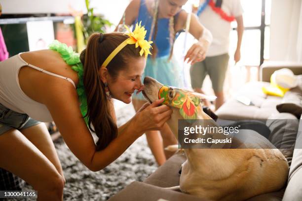 woman kissing her dog's nose during carnival celebration - fiesta stock pictures, royalty-free photos & images