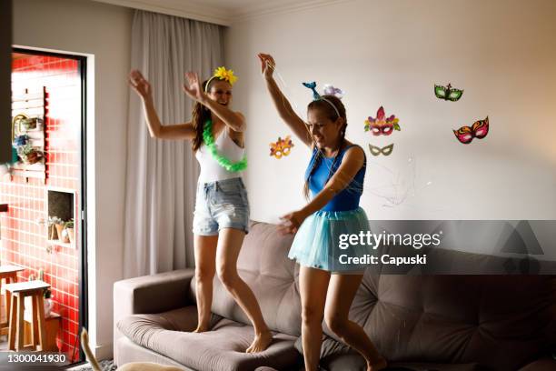 duas jovens dançando no sofá em casa - carnaval do brasil - fotografias e filmes do acervo