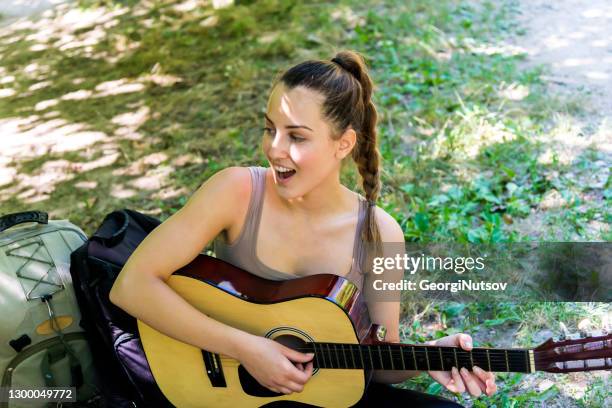 attractive young woman with a guitar in the mountains. - music festival grass stock pictures, royalty-free photos & images