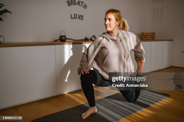 portrait of woman holding low lunge quad stretch pose - quadriceps muscle stock pictures, royalty-free photos & images