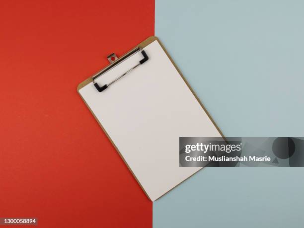 a stack of blank sheets of paper or notepad on a red and soft blue background. creative crisis or the beginning of a new novel. stock photo. - clipboard and glasses stock pictures, royalty-free photos & images