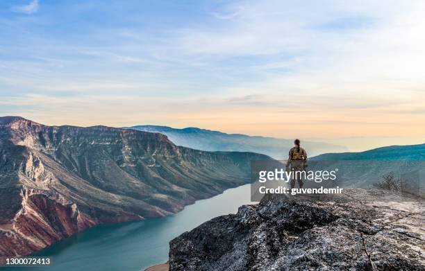 female soldier standing on top of cliff at sunset - valley guns stock pictures, royalty-free photos & images