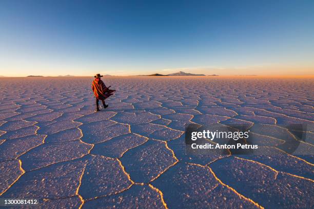 man in poncho at salar de uyuni, aitiplano, bolivia. traveling in bolivia - bolivia stock pictures, royalty-free photos & images