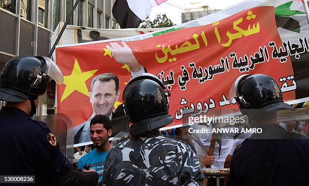 Lebanese security forces stand guard in front of Syrian supporters of embattled President Bashar al-Assad to separate them from a counter-protest...