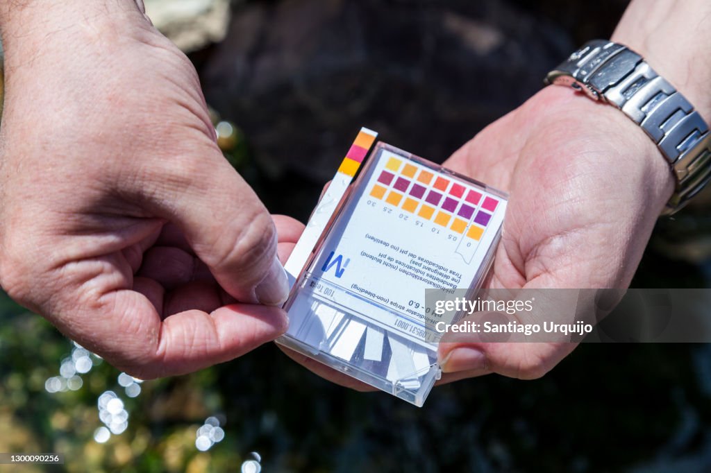 Scientist measuring the ph on a contaminated river