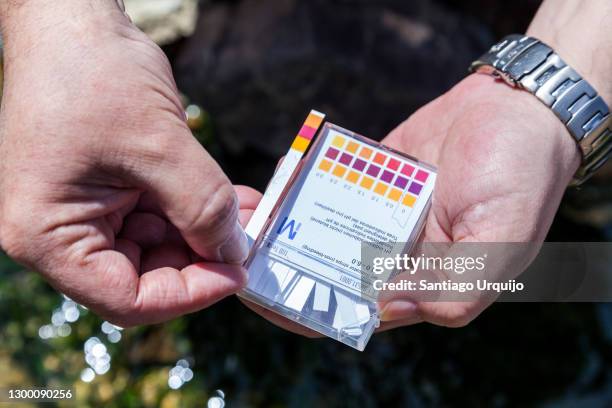 scientist measuring the ph on a contaminated river - ph value stock pictures, royalty-free photos & images