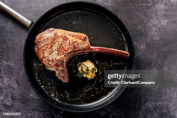 tomahawk steak in a griddle pan - tomahawk stock pictures, royalty-free photos & images