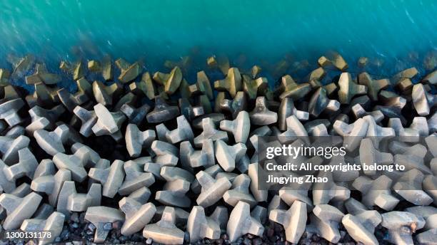 aerial photography of artificial concrete block seawall - groyne photos et images de collection