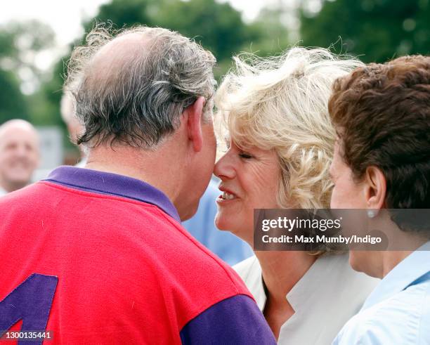 Prince Charles, Prince of Wales kisses Camilla, Duchess of Cornwall as she presents him with his prize after playing in the Burberry Cup polo match...