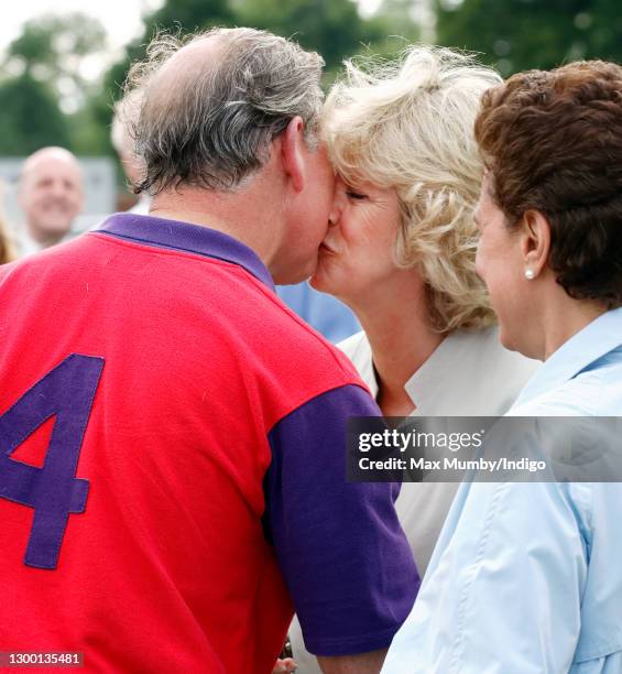 Prince Charles, Prince of Wales kisses Camilla, Duchess of Cornwall as she presents him with his prize after playing in the Burberry Cup polo match...