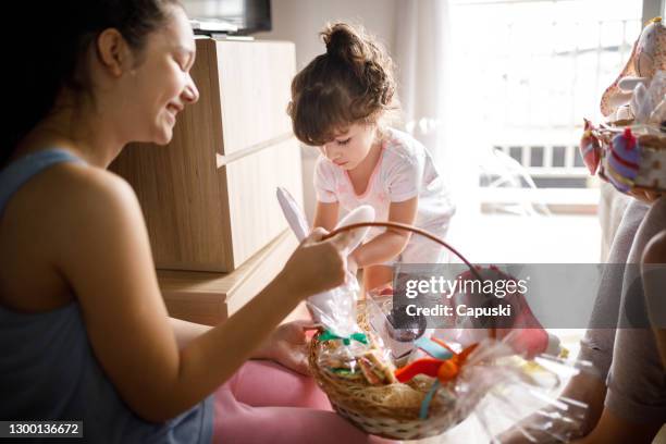 two sisters opening easter basket - easter basket stock pictures, royalty-free photos & images