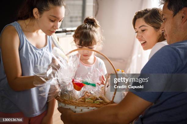 family opening easter basket - easter basket with candy stock pictures, royalty-free photos & images