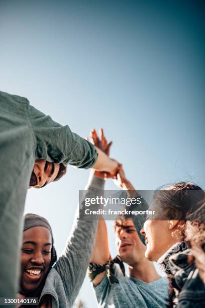 friends teamworking together - community arm in arm stock pictures, royalty-free photos & images