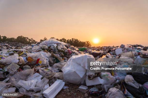 close up large garbage pile near the sunset, global warming - garbage photos et images de collection