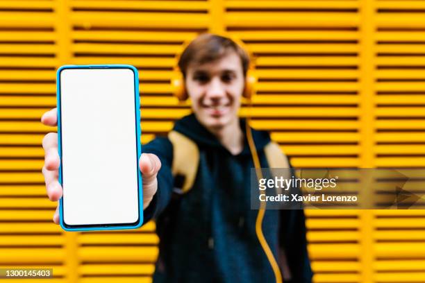happy man showing smartphone screen outdoors - showing stock pictures, royalty-free photos & images