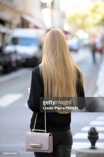 Jeune femme de dos avec un sac à mains porté en bandoulière sur l'Avenue Matignon, 18 octobre 2014, Paris, France.