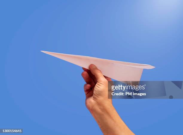 paper airplane in man's hand - business jet stock-fotos und bilder