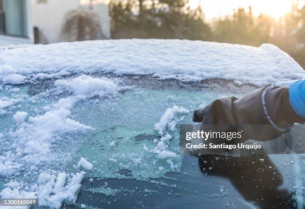 cleaning ice from a car windshield - winter car window stock-fotos und bilder