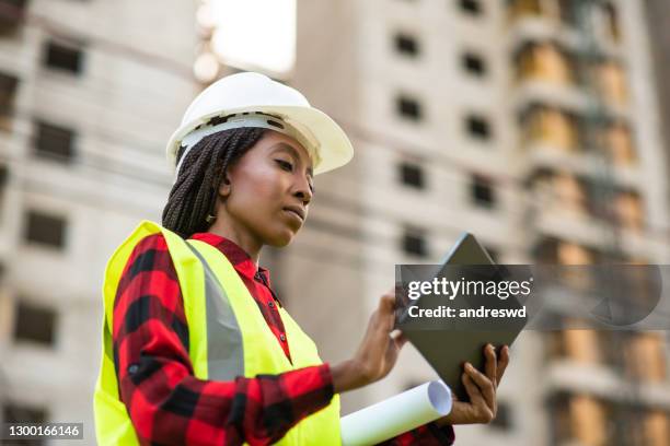 woman at construction site using digital tablet - architekt helm plan stock pictures, royalty-free photos & images