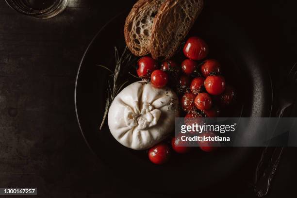 snack with burrata, roasted cherry tomatoes with herbs, and bread - burrata stock pictures, royalty-free photos & images