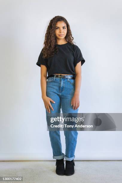 portrait of young woman on white background - jeans neri foto e immagini stock