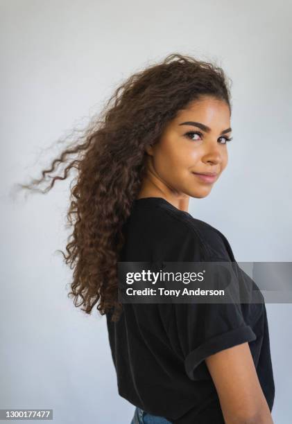 portrait of young woman on white background - looking over shoulder stock pictures, royalty-free photos & images