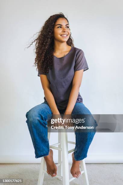 portrait of young woman on white background - jeans barefoot fotografías e imágenes de stock