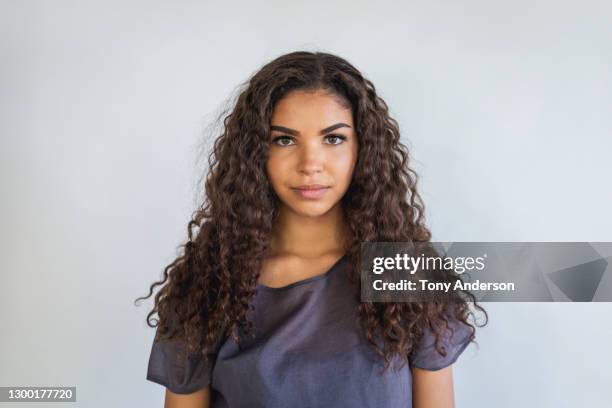 portrait of young woman on white background - curly hair foto e immagini stock