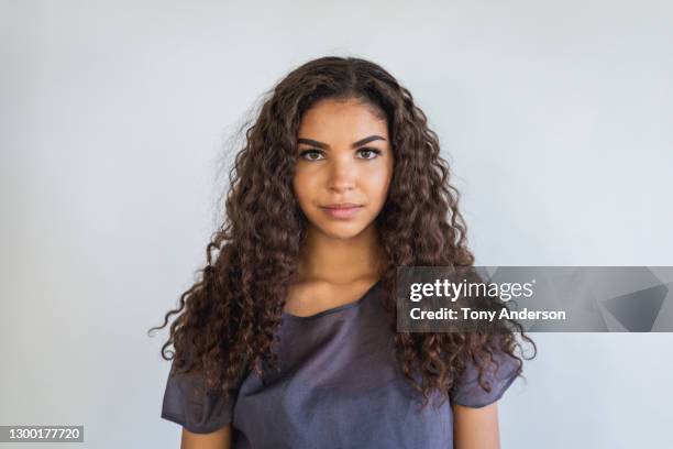 portrait of young woman on white background - curly hair - fotografias e filmes do acervo