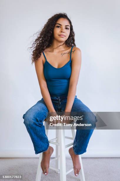 portrait of young woman on white background - woman stool stock pictures, royalty-free photos & images