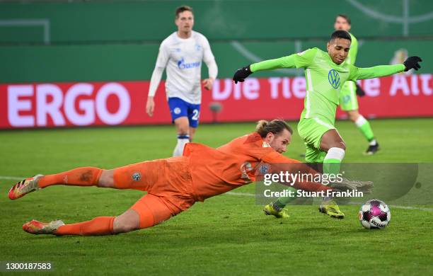 Joao Victor of VfL Wolfsburg is challenged by Ralf Fahrmann of FC Schalke 04 during the DFB Cup Round of Sixteen match between VfL Wolfsburg and FC...