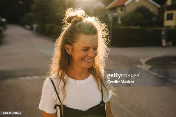 smiling mature woman on road during sunny day - woman smiling facing down stock pictures, royalty-free photos & images