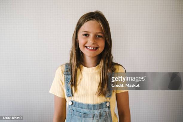 smiling girl against white wall at home - 10 11 jaar stockfoto's en -beelden