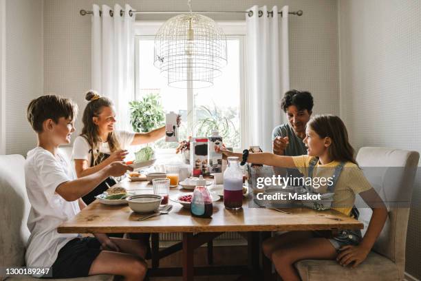 parents having breakfast with children over table at home - the brunch stockfoto's en -beelden