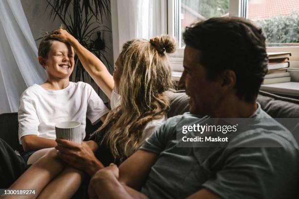 happy parents spending time with son in living room - living room young couple stock-fotos und bilder