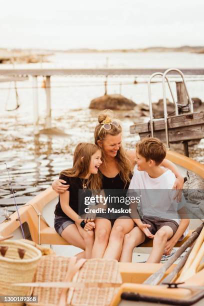 happy family sitting in boat during summer vacation - archipelago stockfoto's en -beelden