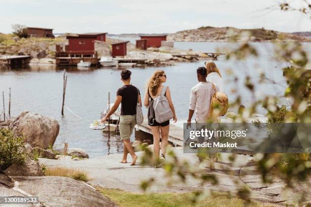 rear view of friends looking at sea during summer vacation - göteborg stock-fotos und bilder