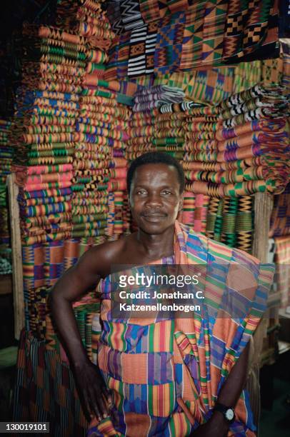 Kente cloth seller stands in front of his stock in a market in Accra, Ghana, November 1996.