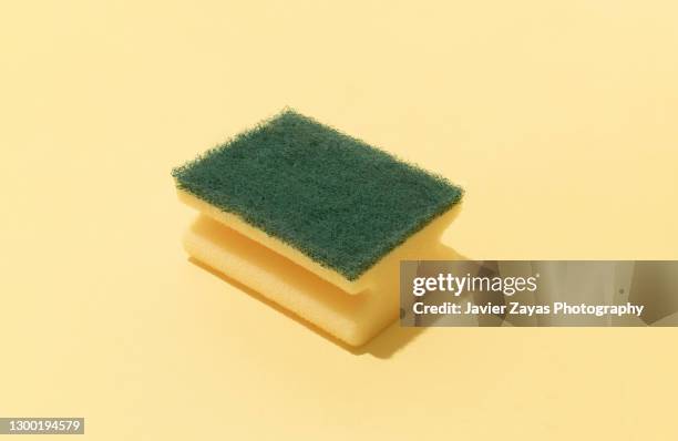 scouring pad on yellow background - spugna per le pulizie foto e immagini stock