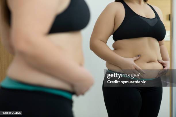 mujer con abdomen gordo - grasas fotografías e imágenes de stock