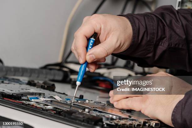 man repairing computer with a screwdriver in his hands - screwdriver stock pictures, royalty-free photos & images
