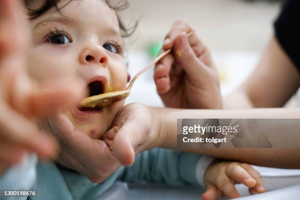 mutter füttert baby mit löffel - refusing stock-fotos und bilder
